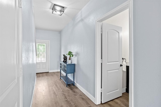 hall with baseboards and wood finished floors