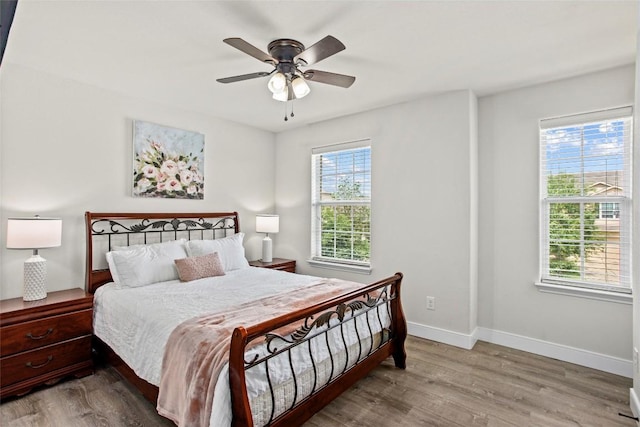 bedroom featuring baseboards, ceiling fan, and wood finished floors