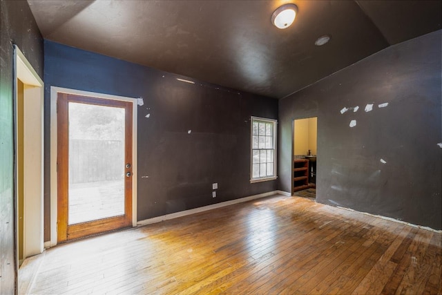 unfurnished room featuring vaulted ceiling and hardwood / wood-style floors