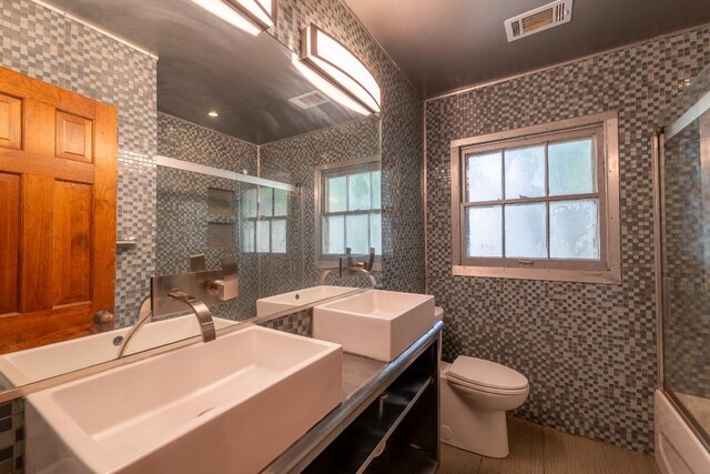 2907 Pinecrest Dr, Austin, TX 78757 - bathroom with tile walls, an enclosed shower, toilet, double vanity, and a tub