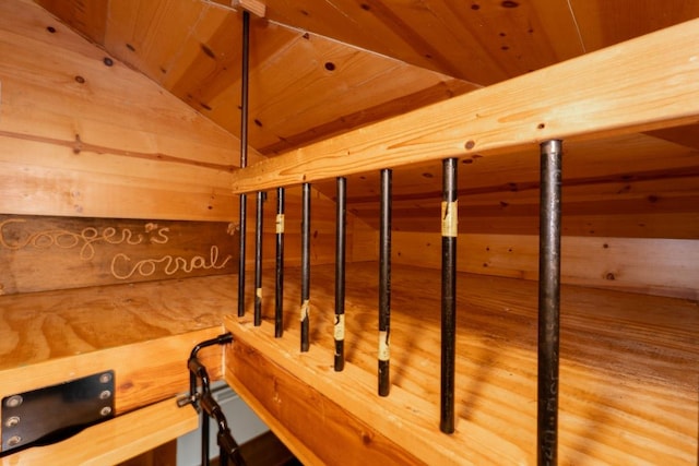 stairs with wooden walls, vaulted ceiling, and wooden ceiling
