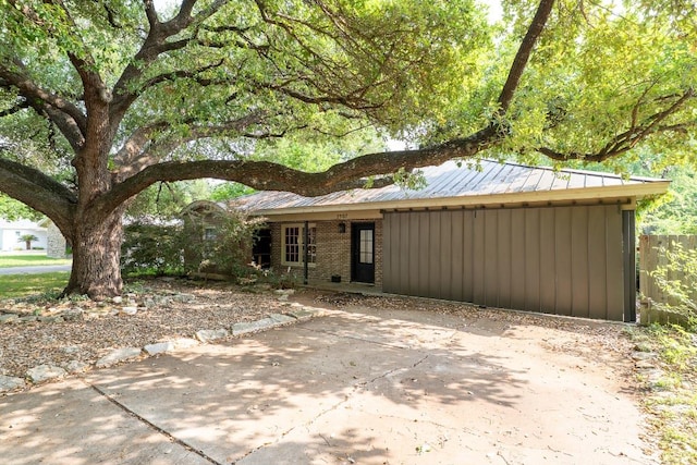 view of front of house featuring fence and metal roof