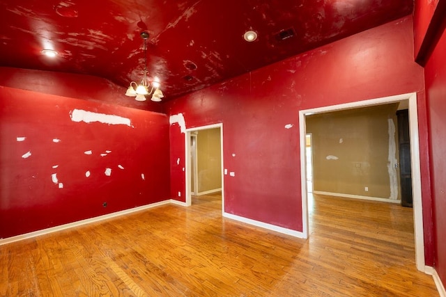 empty room featuring visible vents, baseboards, and wood finished floors