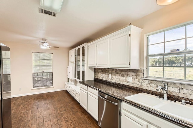 kitchen featuring visible vents, white cabinetry, tasteful backsplash, a sink, and dishwasher