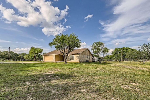 view of yard featuring fence and an attached garage