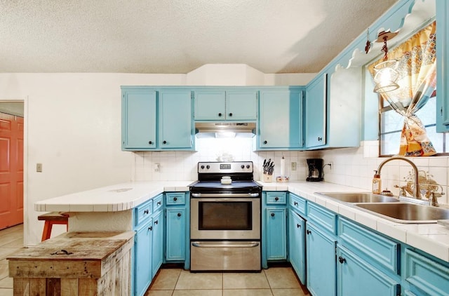 kitchen featuring a sink, blue cabinetry, light tile patterned flooring, and stainless steel range with electric stovetop