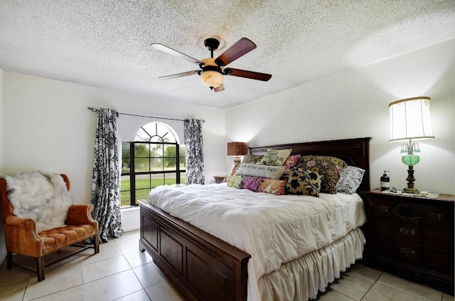 bedroom featuring a ceiling fan, a textured ceiling, and light tile patterned floors