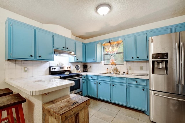 kitchen with a sink, blue cabinetry, and stainless steel appliances
