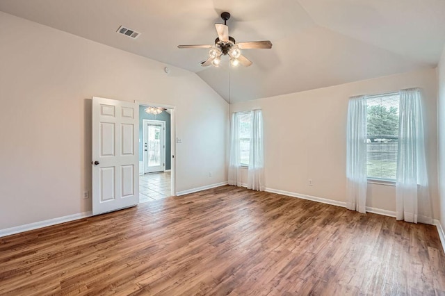 empty room featuring baseboards, a ceiling fan, wood finished floors, and vaulted ceiling