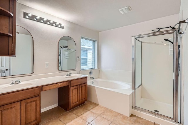 bathroom with a garden tub, a sink, tile patterned flooring, and a shower stall