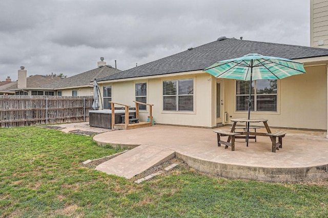 back of house featuring fence, a shingled roof, a yard, and a patio area