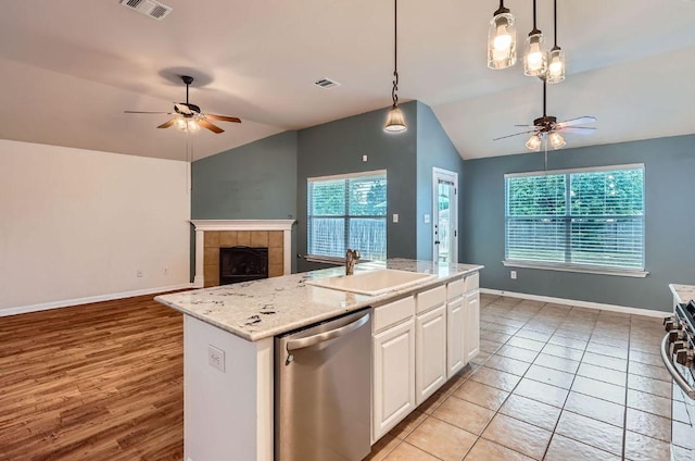 kitchen with stainless steel dishwasher, a sink, ceiling fan, and vaulted ceiling