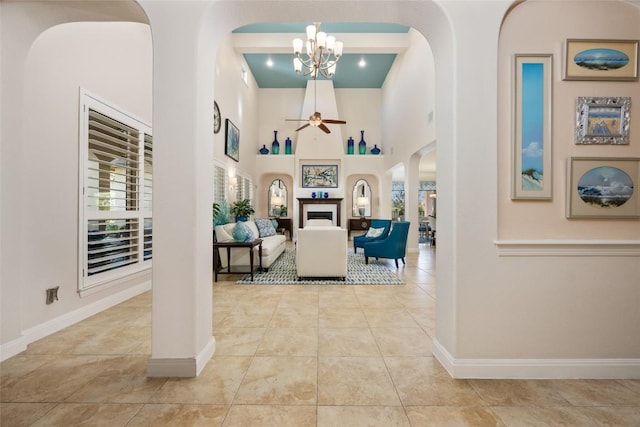 228 Cimarron Hills Trl E, Georgetown, TX 78628 - entrance foyer featuring a fireplace, arched walkways, a chandelier, tile patterned flooring, and a towering ceiling
