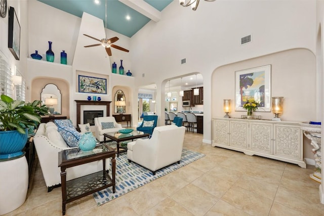 228 Cimarron Hills Trl E, Georgetown, TX 78628 - living area with arched walkways, ceiling fan, high vaulted ceiling, a fireplace, and beamed ceiling