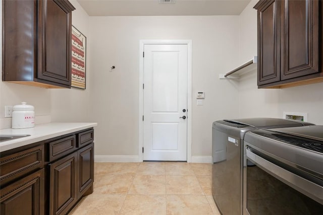 228 Cimarron Hills Trl E, Georgetown, TX 78628 - laundry room with cabinet space, washer and dryer, and light tile patterned floors