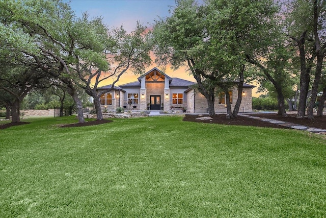 view of front of house featuring stone siding and a front yard