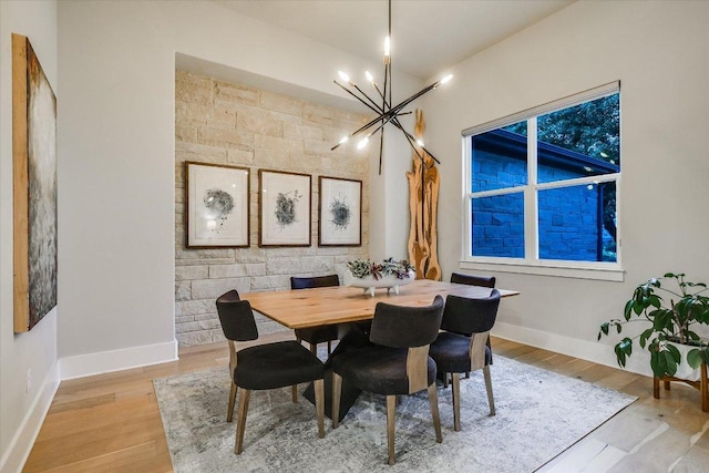 dining space featuring an inviting chandelier, light wood-style floors, and baseboards