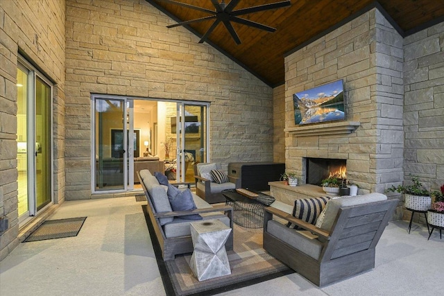 view of patio / terrace with ceiling fan and an outdoor living space with a fireplace