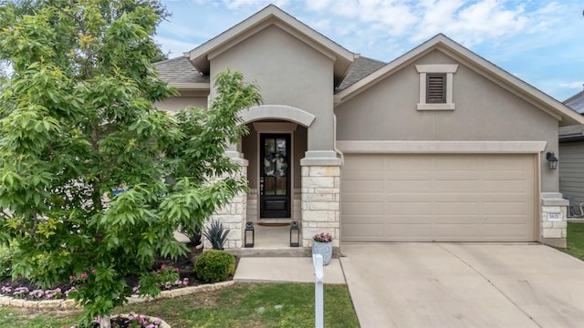 1621 Winding Stream Trl, Leander, TX 78641 - view of front of home with an attached garage, stucco siding, roof with shingles, driveway, and stone siding