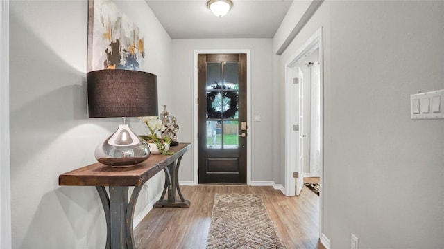 foyer featuring baseboards and wood finished floors