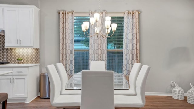 dining room featuring baseboards, wood finished floors, and a chandelier