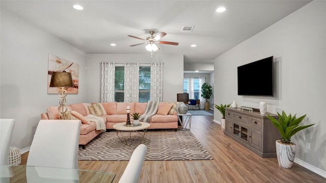 living room with baseboards, a ceiling fan, wood finished floors, and visible vents