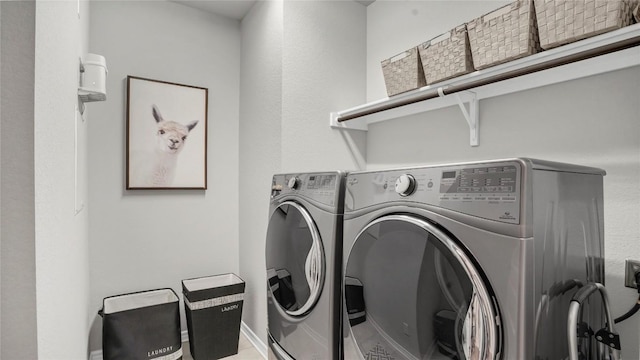 laundry room featuring baseboards, laundry area, and washer and clothes dryer