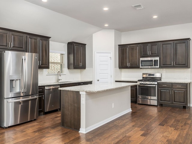 kitchen with dark brown cabinetry, appliances with stainless steel finishes, a sink, recessed lighting, and visible vents