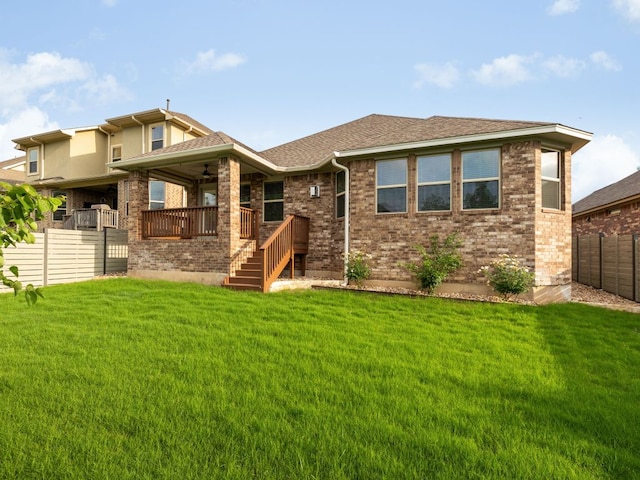 back of house with a lawn, ceiling fan, fence, and brick siding