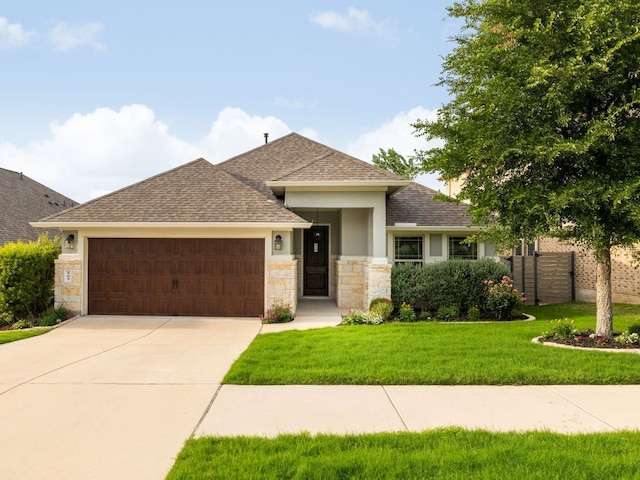 ranch-style house with fence, a front yard, stone siding, roof with shingles, and an attached garage
