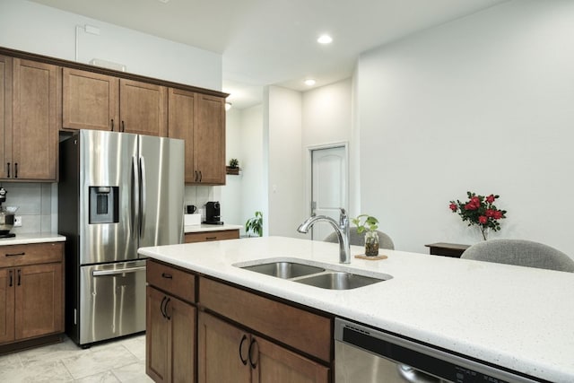 kitchen featuring recessed lighting, a sink, decorative backsplash, and stainless steel appliances