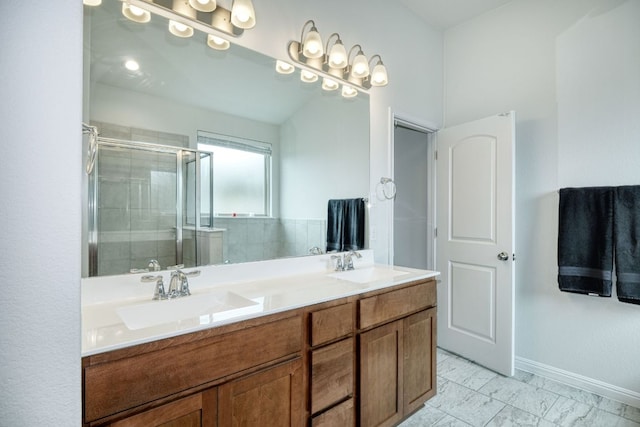bathroom with double vanity, a sink, baseboards, and a shower stall