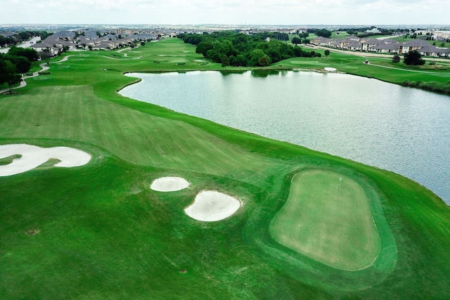 drone / aerial view with a water view, view of golf course, and a residential view