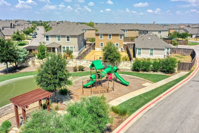 communal playground with fence and a residential view