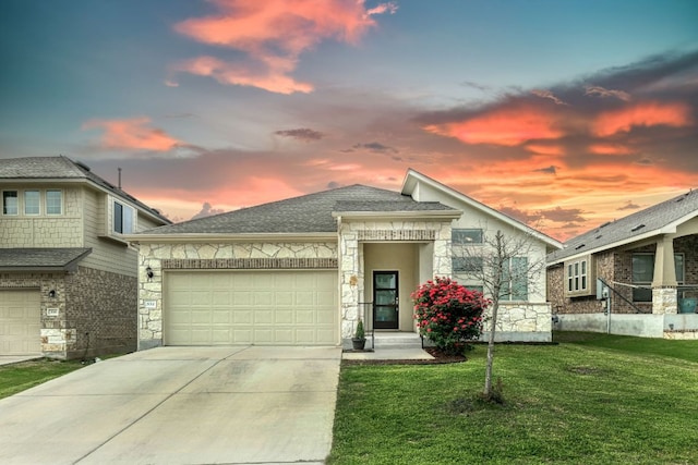 view of front of house with a lawn, a garage, concrete driveway, a shingled roof, and stone siding