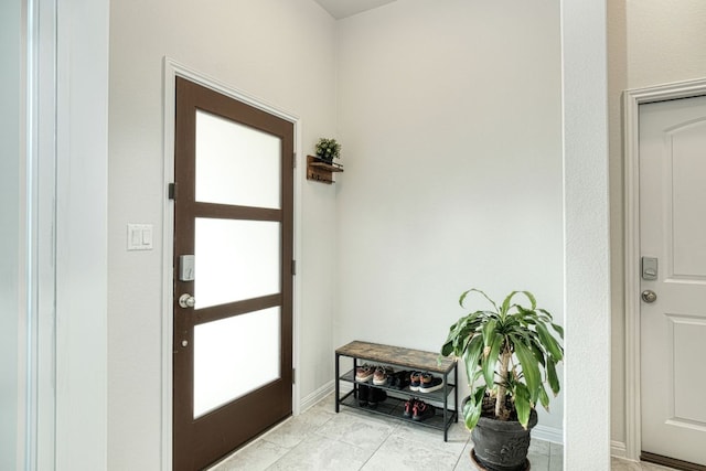 entryway featuring baseboards and light tile patterned floors