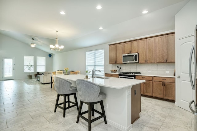 kitchen with a sink, appliances with stainless steel finishes, plenty of natural light, and a kitchen bar
