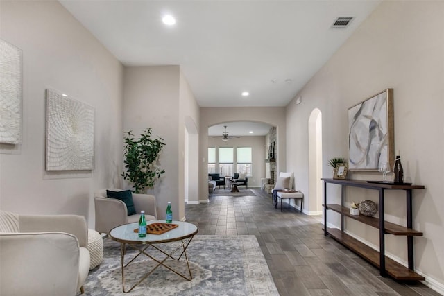 hall featuring arched walkways, baseboards, visible vents, and recessed lighting