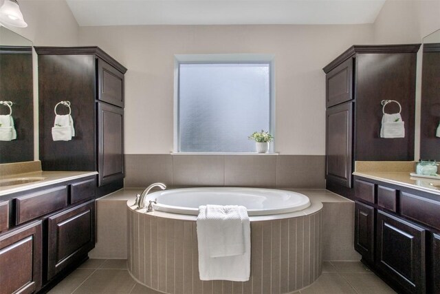 108 Poppy Ct, Georgetown, TX 78626 - full bathroom featuring two vanities, tile patterned flooring, and a garden tub