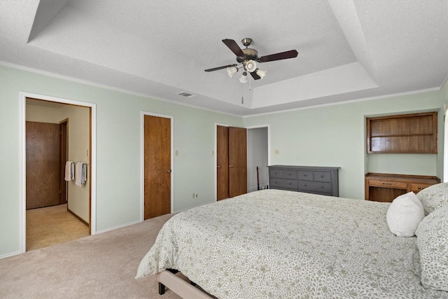9800 Knotty Pine Cv, Austin, TX 78750 - carpeted bedroom featuring a ceiling fan, a textured ceiling, visible vents, ensuite bathroom, and a tray ceiling
