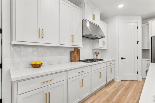 8401 Hubble Walk, Austin, TX 78744 - kitchen featuring under cabinet range hood, light wood finished floors, light countertops, white cabinetry, and recessed lighting