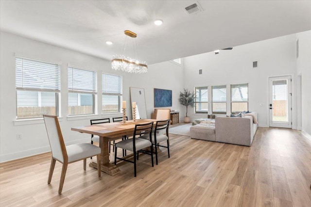 dining area with baseboards, visible vents, an inviting chandelier, and light wood-style floors