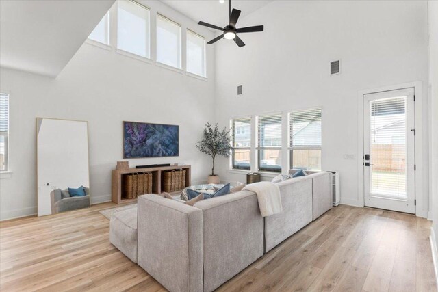 8401 Hubble Walk, Austin, TX 78744 - living area with a ceiling fan, a towering ceiling, light wood-style floors, and healthy amount of natural light