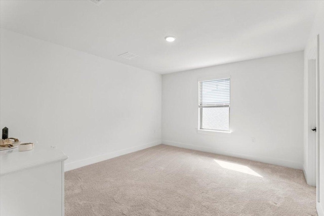 unfurnished room featuring baseboards, recessed lighting, and light colored carpet
