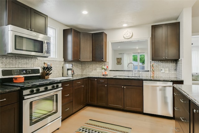 kitchen with a sink, decorative backsplash, and stainless steel appliances
