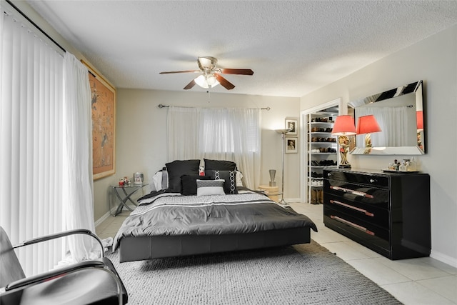 6702 Langston Dr, Austin, TX 78723 - bedroom with light tile patterned floors, a textured ceiling, baseboards, and a ceiling fan