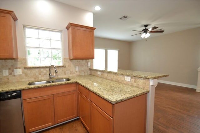 kitchen with a sink, dark wood finished floors, a peninsula, tasteful backsplash, and stainless steel dishwasher