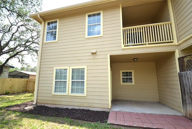 back of property with fence and a balcony