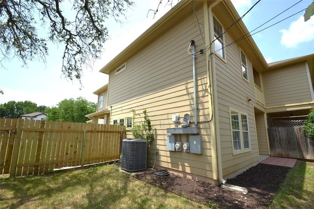 view of side of home featuring fence and cooling unit