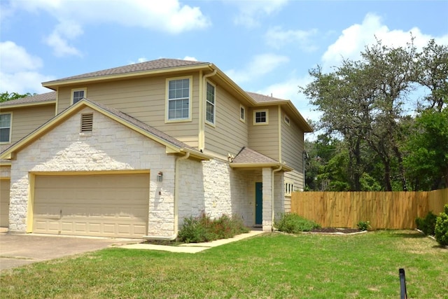 view of front facade with fence, stone siding, a garage, a front yard, and concrete driveway
